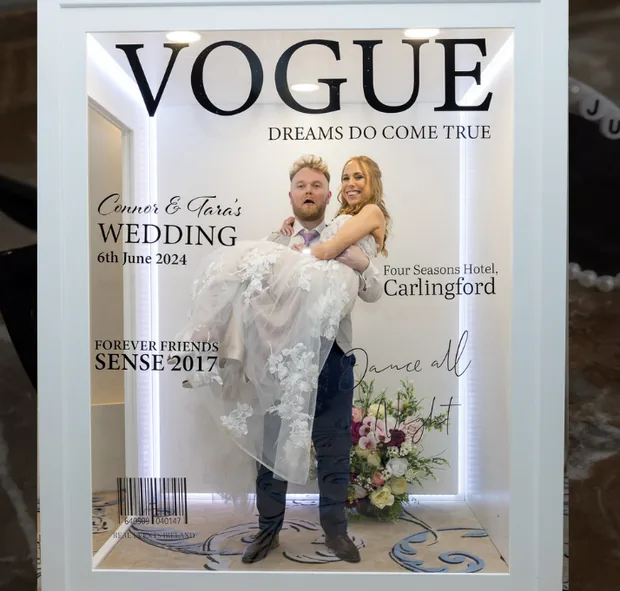 Couple posing inside the magazine-cover-style Vogue Booth